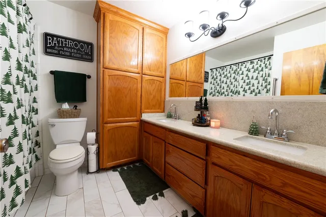 a bathroom with a sink toilet a mirror and shower