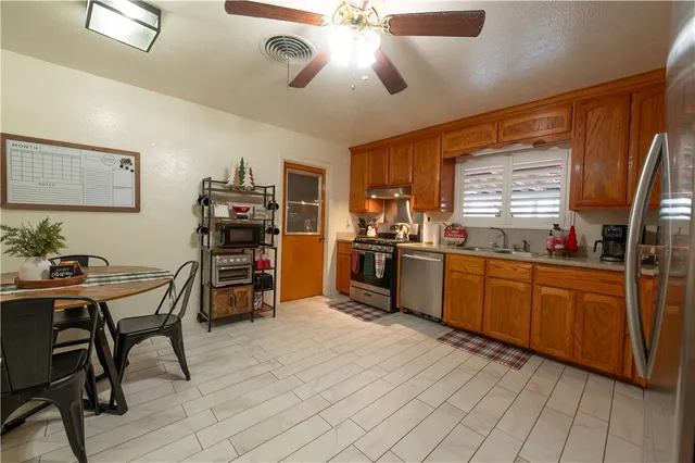 a kitchen with stainless steel appliances kitchen island granite countertop a sink cabinets and wooden floor