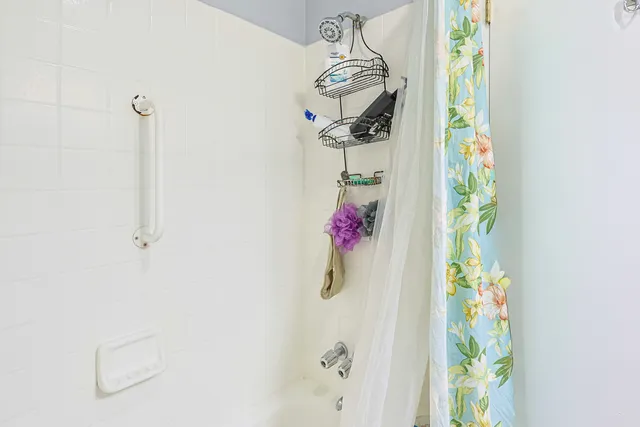 a bathroom with a shower curtain and mirror