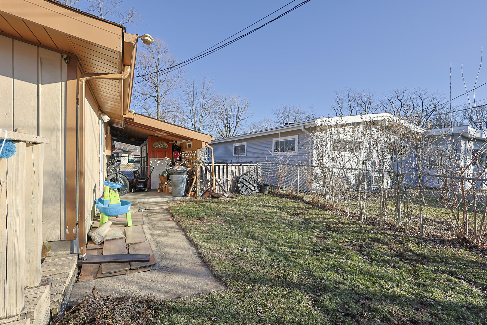 372 Nancy Lane Wheeling, IL 60090 - Photo 28 of 28 a view of a porch with a table and chairs under an umbrella
