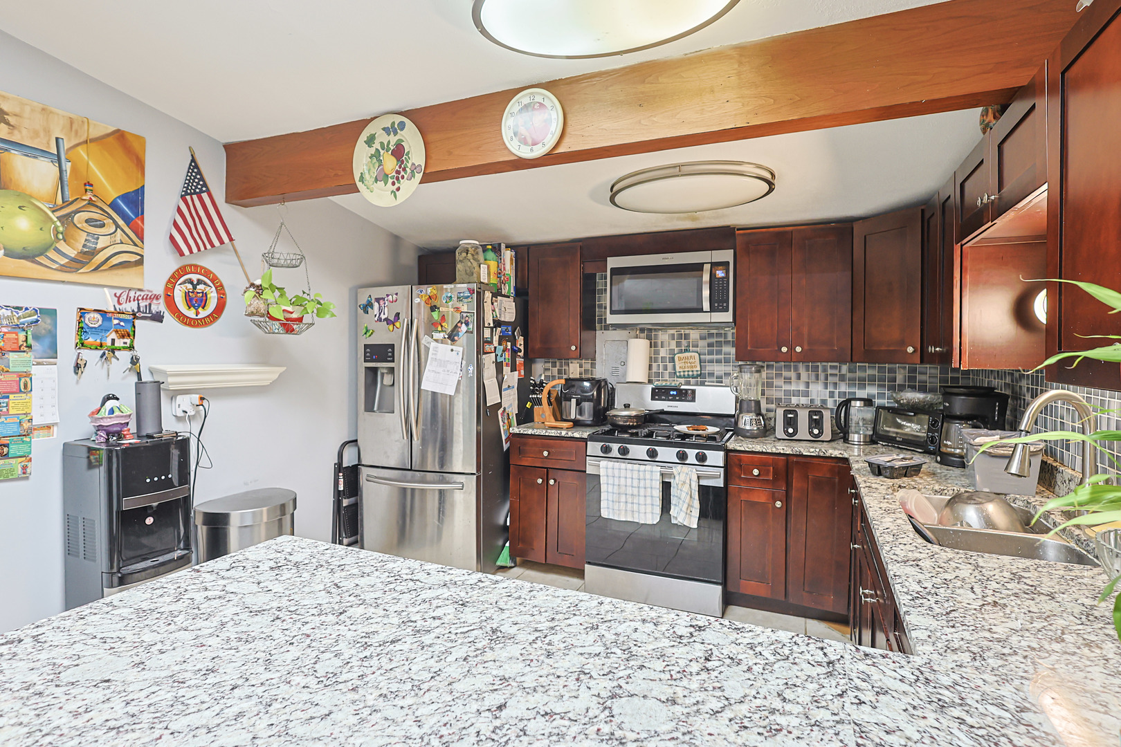 372 Nancy Lane Wheeling, IL 60090 - Photo 6 of 28 a kitchen with stainless steel appliances granite countertop a refrigerator a stove and a sink with wooden floor