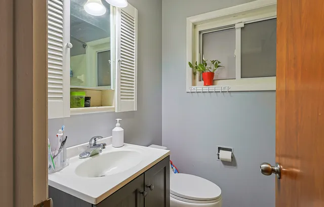 a bathroom with a sink vanity mirror and toilet