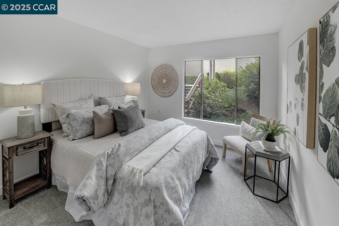 2940 Tice Creek Drive, Unit 6 Walnut Creek, CA 94595 - Photo 22 of 49 a bedroom with a bed and a large window