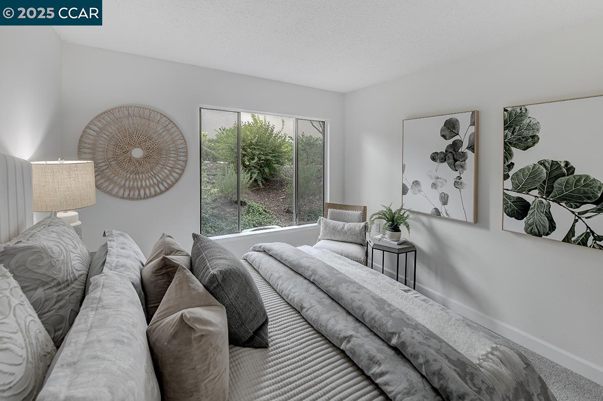 2940 Tice Creek Drive, Unit 6 Walnut Creek, CA 94595 - Photo 23 of 49 a bedroom with a large bed and a large window