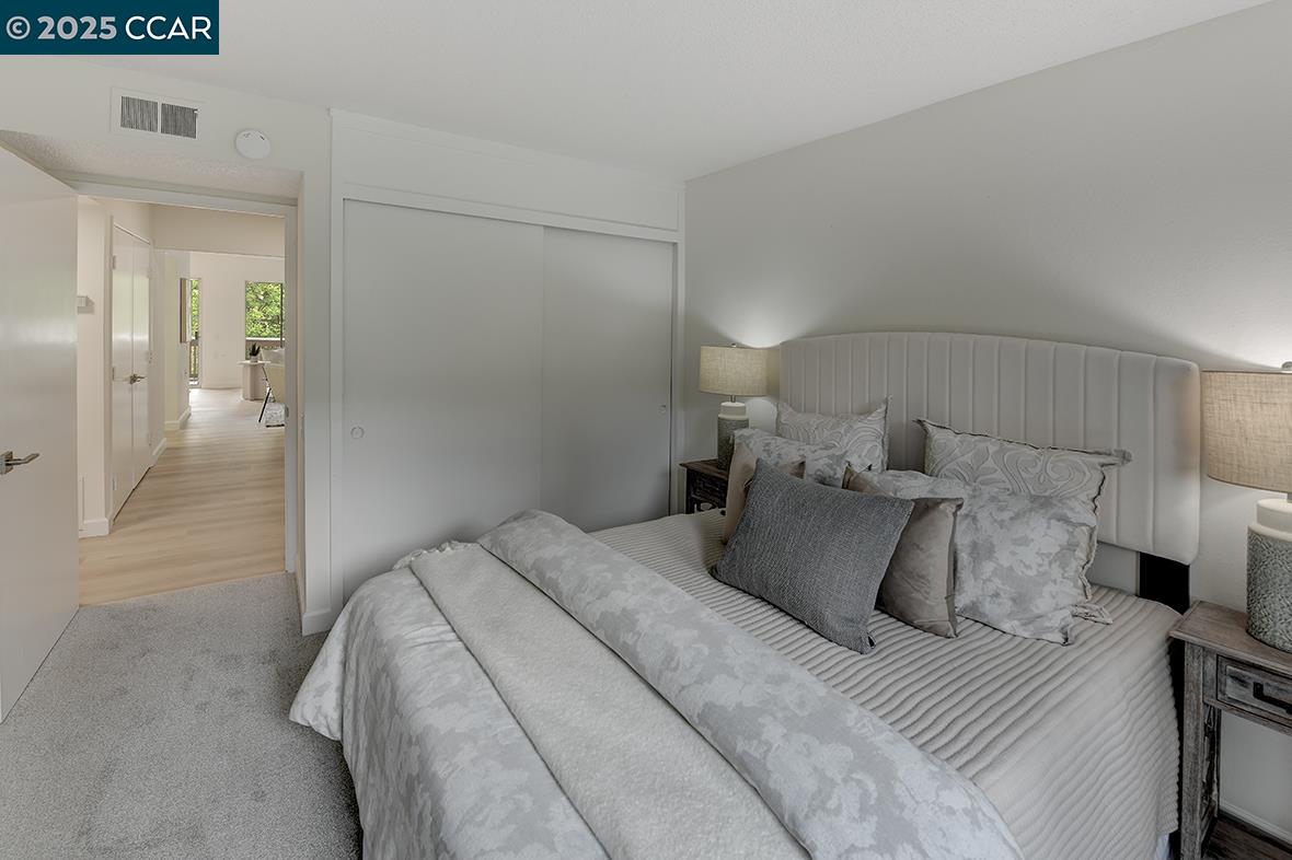 2940 Tice Creek Drive, Unit 6 Walnut Creek, CA 94595 - Photo 25 of 49 a bedroom with a bed and a mirror