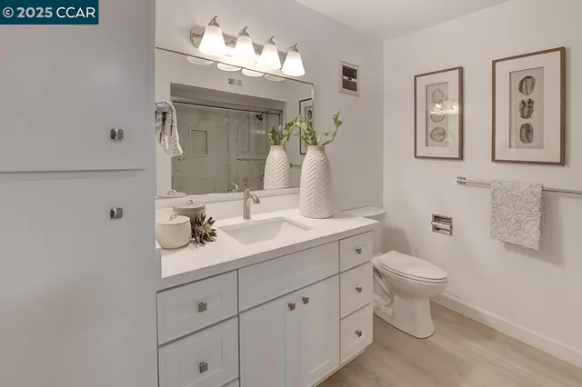 a bathroom with a toilet a sink and mirror