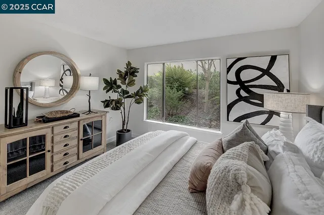 a spacious bedroom with a bed a dresser and mirror