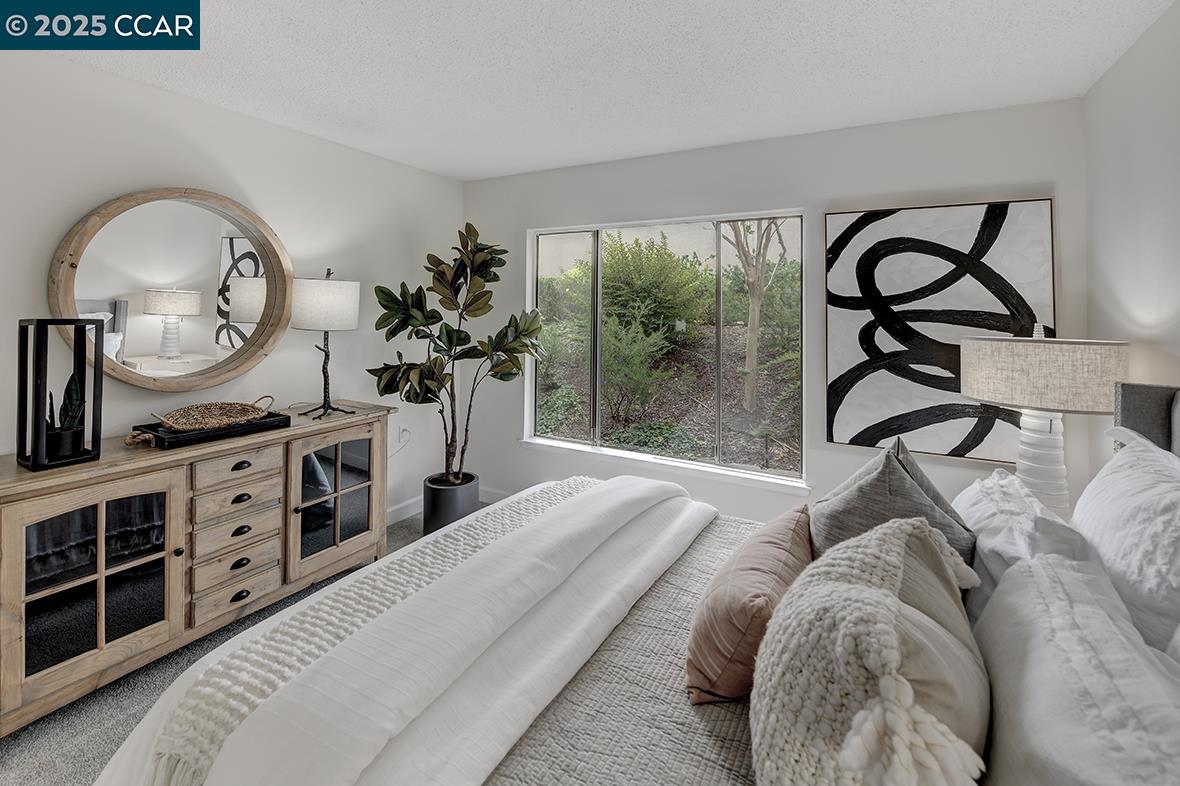 2940 Tice Creek Drive, Unit 6 Walnut Creek, CA 94595 - Photo 31 of 49 a spacious bedroom with a bed a dresser and mirror