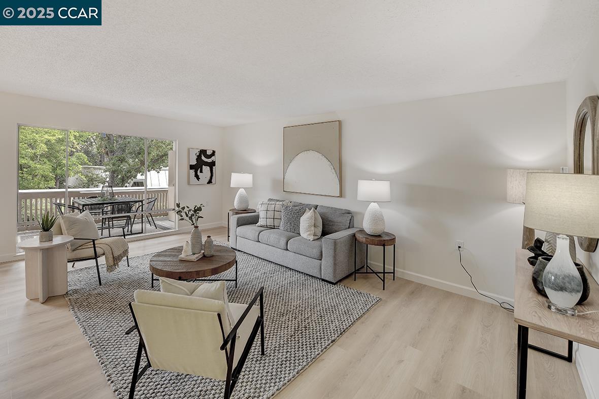 2940 Tice Creek Drive, Unit 6 Walnut Creek, CA 94595 - Photo 4 of 49 a living room with furniture a lamp and a table