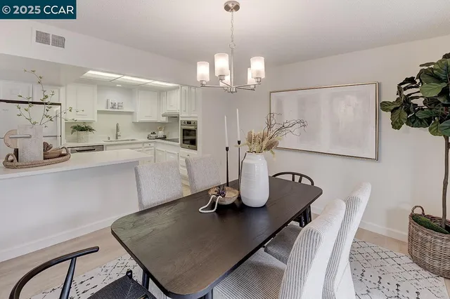 a kitchen with a table chairs and white cabinets
