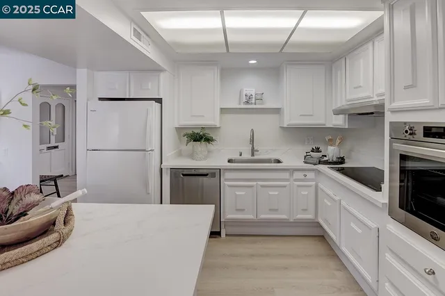 a kitchen with cabinets and stainless steel appliances