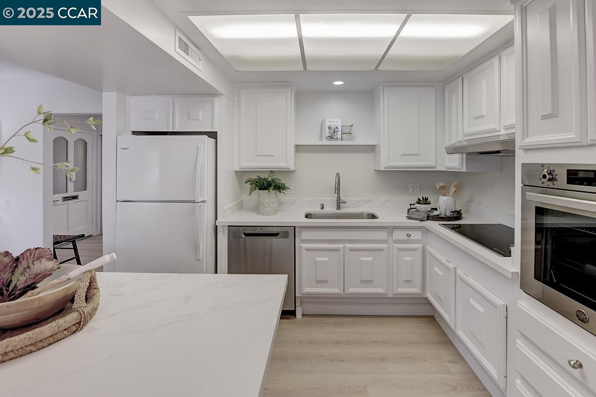 2940 Tice Creek Drive, Unit 6 Walnut Creek, CA 94595 - Photo 8 of 49 a kitchen with cabinets and stainless steel appliances