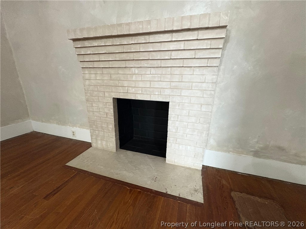 3174 Lindsay Road Raeford, NC 28376 - Photo 7 of 28 a view of an empty room with wooden floor and a fireplace
