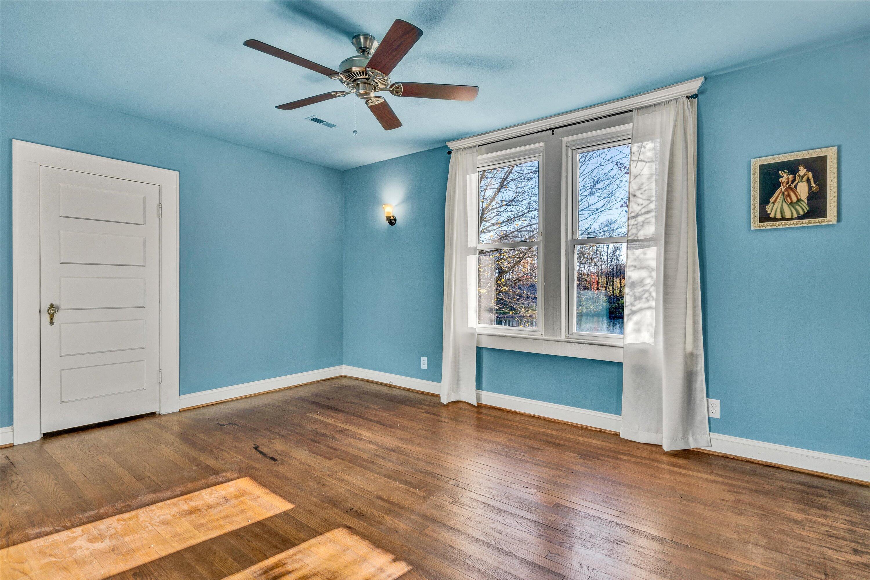 370 Rustic Ridge Road Stuart, VA 24171 - Photo 21 of 42 an empty room with wooden floor and windows