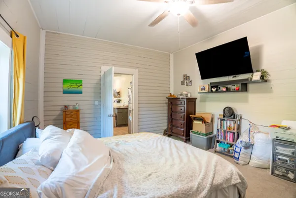 a bedroom with a bed and a flat tv screen on the dresser