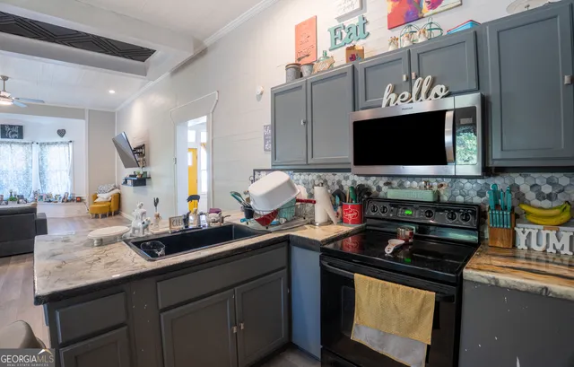 a kitchen with stainless steel appliances a sink stove and microwave