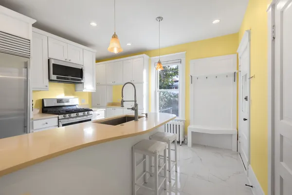 a kitchen with a refrigerator and a stove top oven