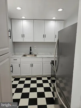 a kitchen with a checkered floor and white cabinets
