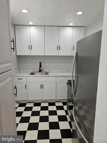 a kitchen with a checkered floor and white cabinets