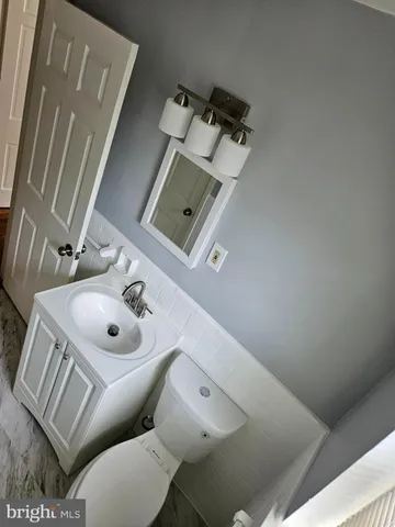 a bathroom with a sink and mirror with toilet