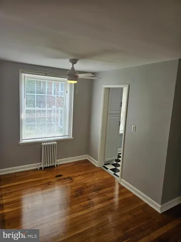 an empty room with wooden floor and a window