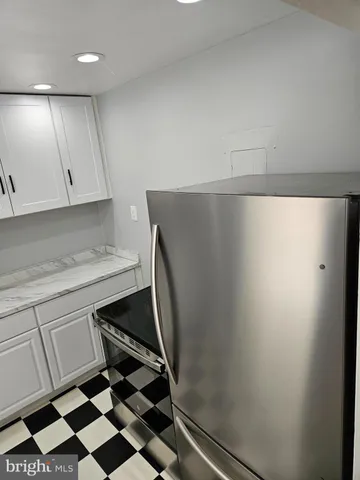 a kitchen with a sink a refrigerator and cabinets