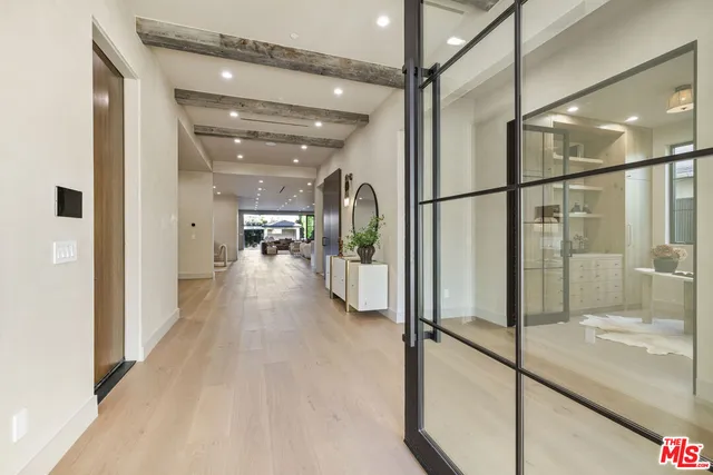 a view of a hallway with wooden floor and windows