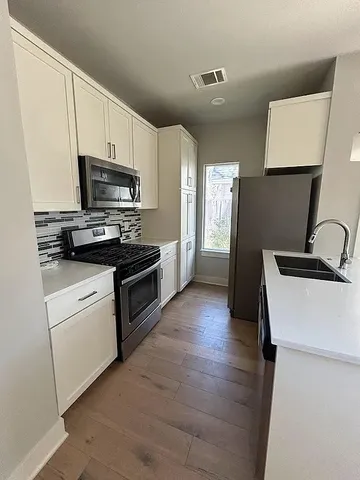 a kitchen with a sink a stove and refrigerator
