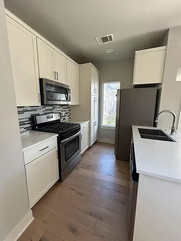 a kitchen with a sink a stove and refrigerator