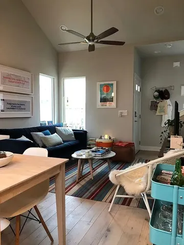 a living room with furniture kitchen view and a window