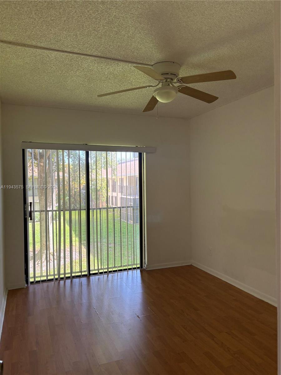 5981 Washington Street, Unit 215 Hollywood, FL 33023 - Photo 11 of 24 an empty room with wooden floor fan and windows