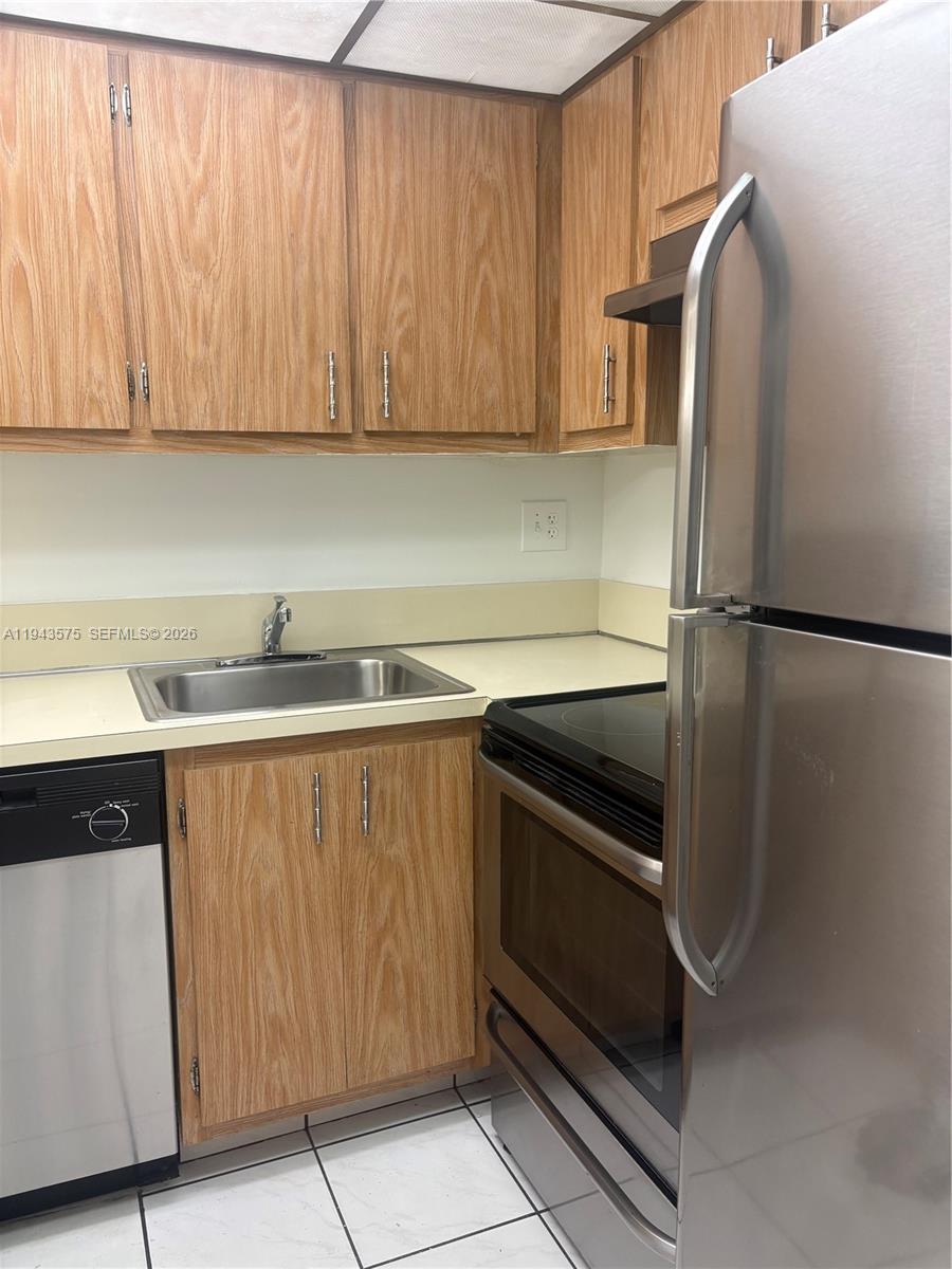 5981 Washington Street, Unit 215 Hollywood, FL 33023 - Photo 12 of 24 a kitchen with a refrigerator and cabinets