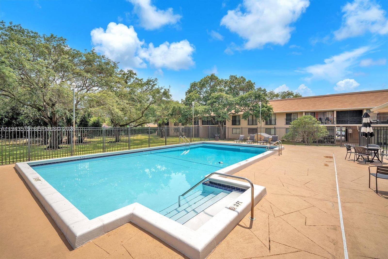 5981 Washington Street, Unit 215 Hollywood, FL 33023 - Photo 3 of 24 a view of a swimming pool with a patio and a yard