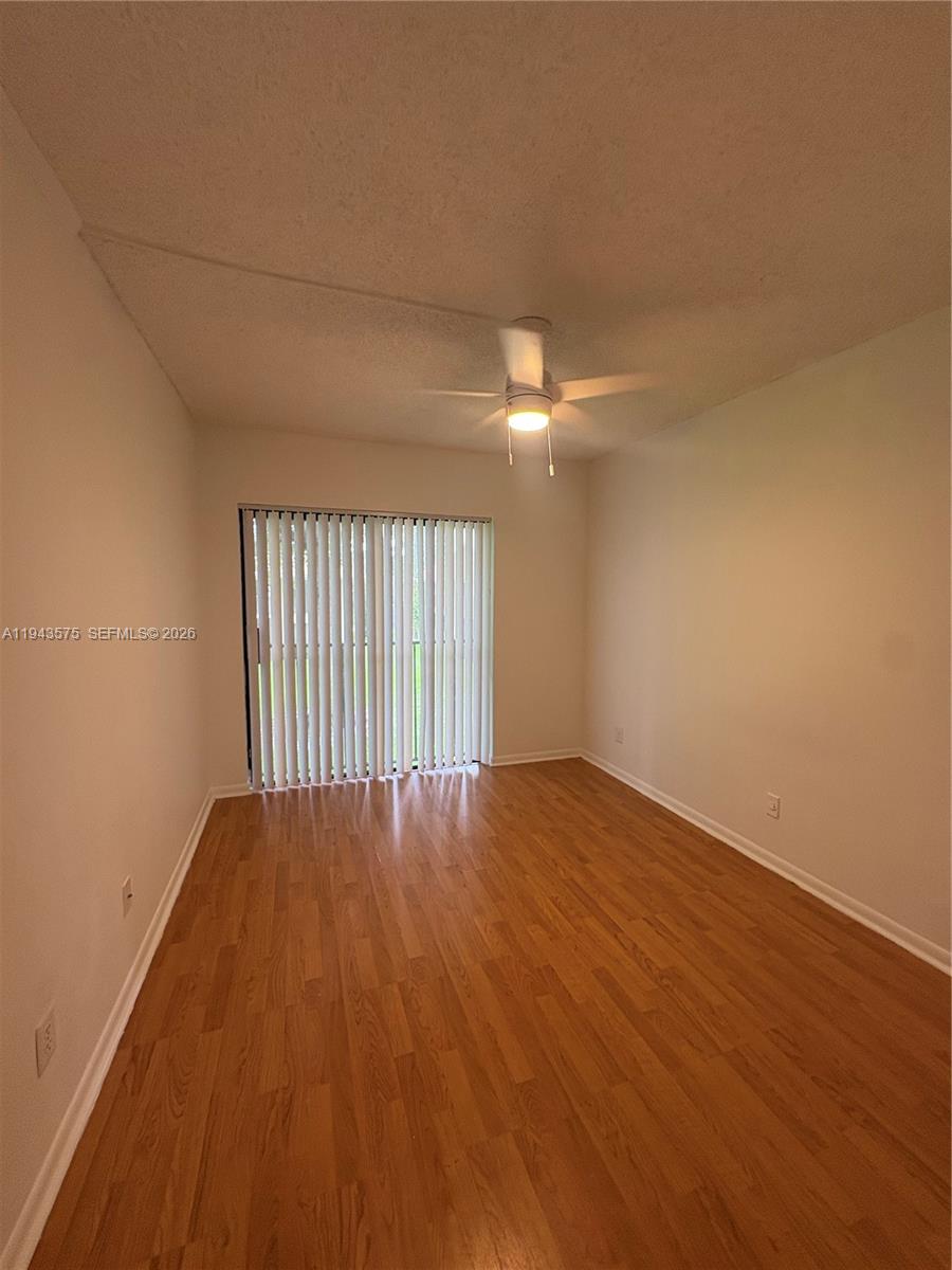 5981 Washington Street, Unit 215 Hollywood, FL 33023 - Photo 9 of 24 an empty room with wooden floor and windows