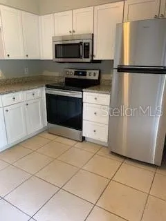a kitchen with granite countertop a sink a stove and cabinets