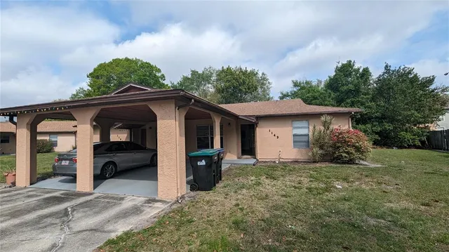 a view of a house with a yard and large tree