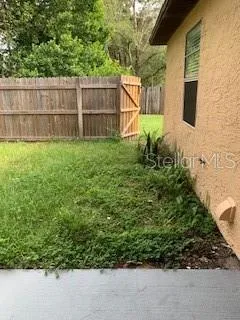 a backyard of a house with lots of green space and wooden fence