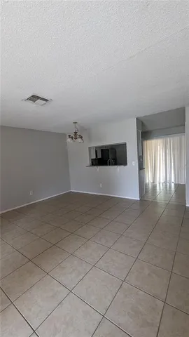 a view of a livingroom with a chandelier fan and windows