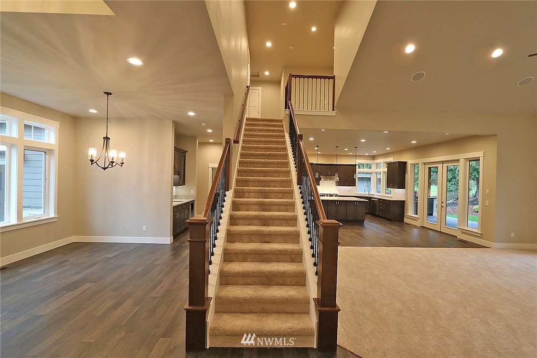 8826 Goshawk Road Blaine, WA 98230 - Photo 14 of 24 a view of a hallway with wooden floor and stairs