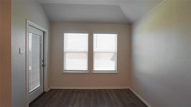 a view of a room with wooden floor and windows