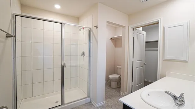 a bathroom with a shower a sink and toilet