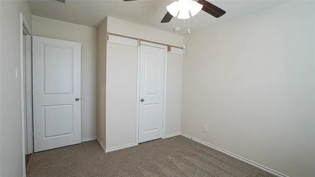 an empty room with a chandelier fan