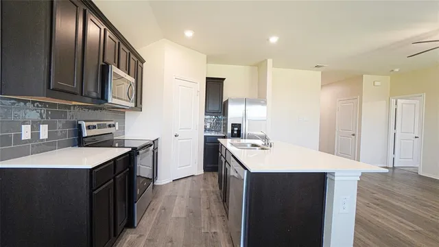 a kitchen with stainless steel appliances granite countertop a sink stove and refrigerator