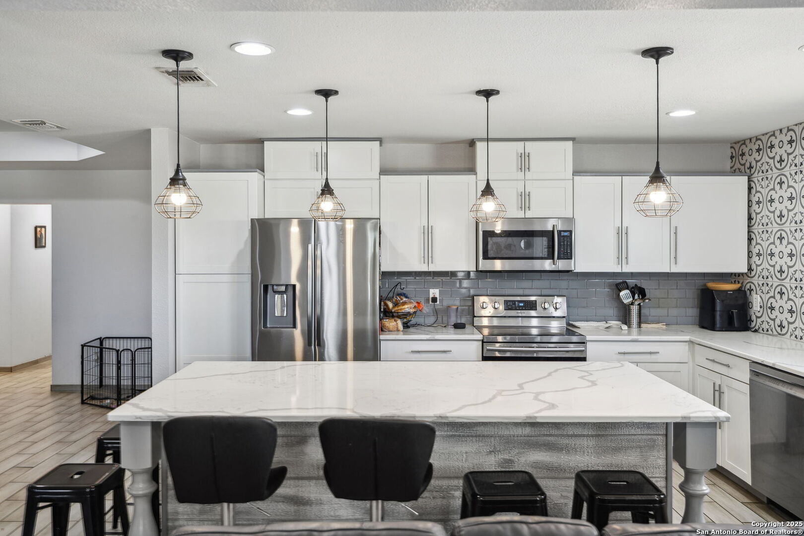 2355 Stuart Road Adkins, TX 78101 - Photo 5 of 46 a kitchen with stainless steel appliances kitchen island granite countertop a table chairs and a refrigerator
