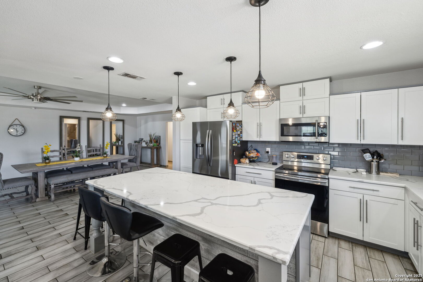 2355 Stuart Road Adkins, TX 78101 - Photo 7 of 46 a kitchen with stainless steel appliances kitchen island a table chairs and a refrigerator