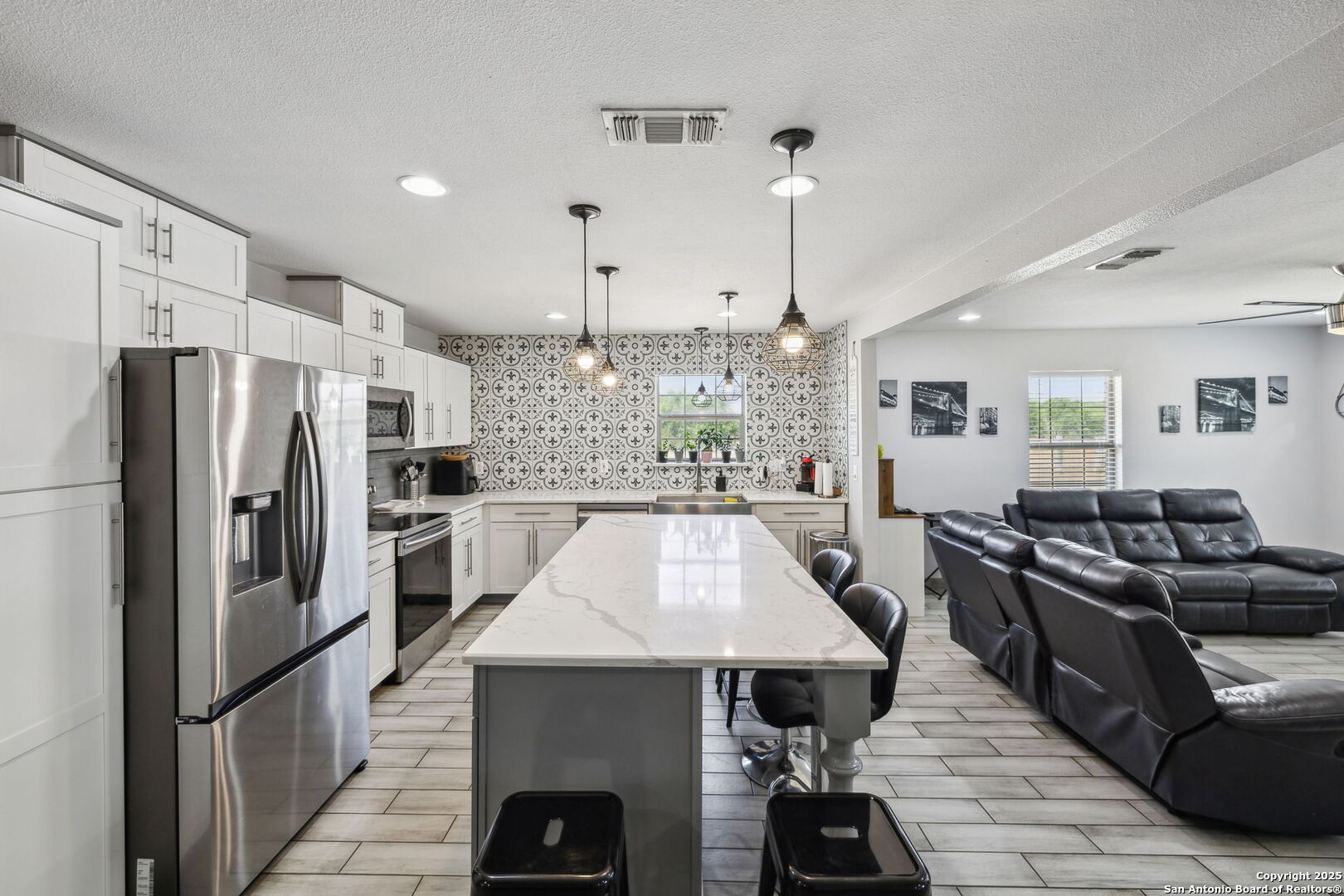 2355 Stuart Road Adkins, TX 78101 - Photo 10 of 46 a kitchen with stainless steel appliances kitchen island granite countertop a refrigerator a stove a oven a sink with island chairs and wooden floor