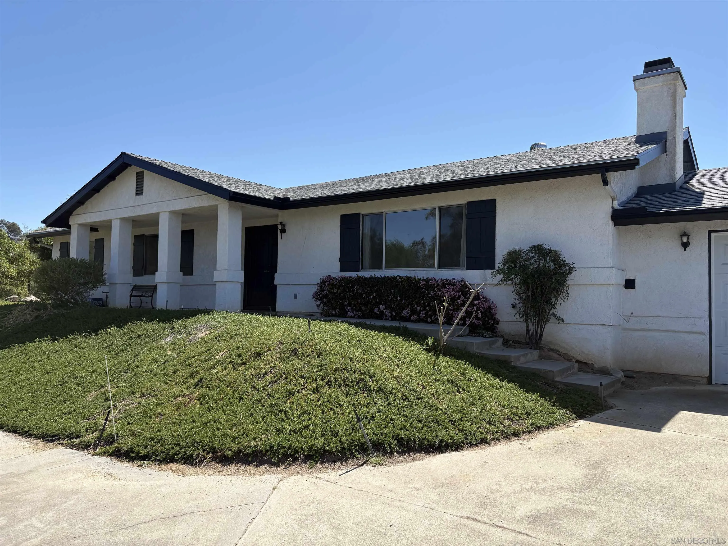 6702 Rainbow Heights Road Rainbow, CA 92028 - Photo 1 of 37 a front view of a house with garden
