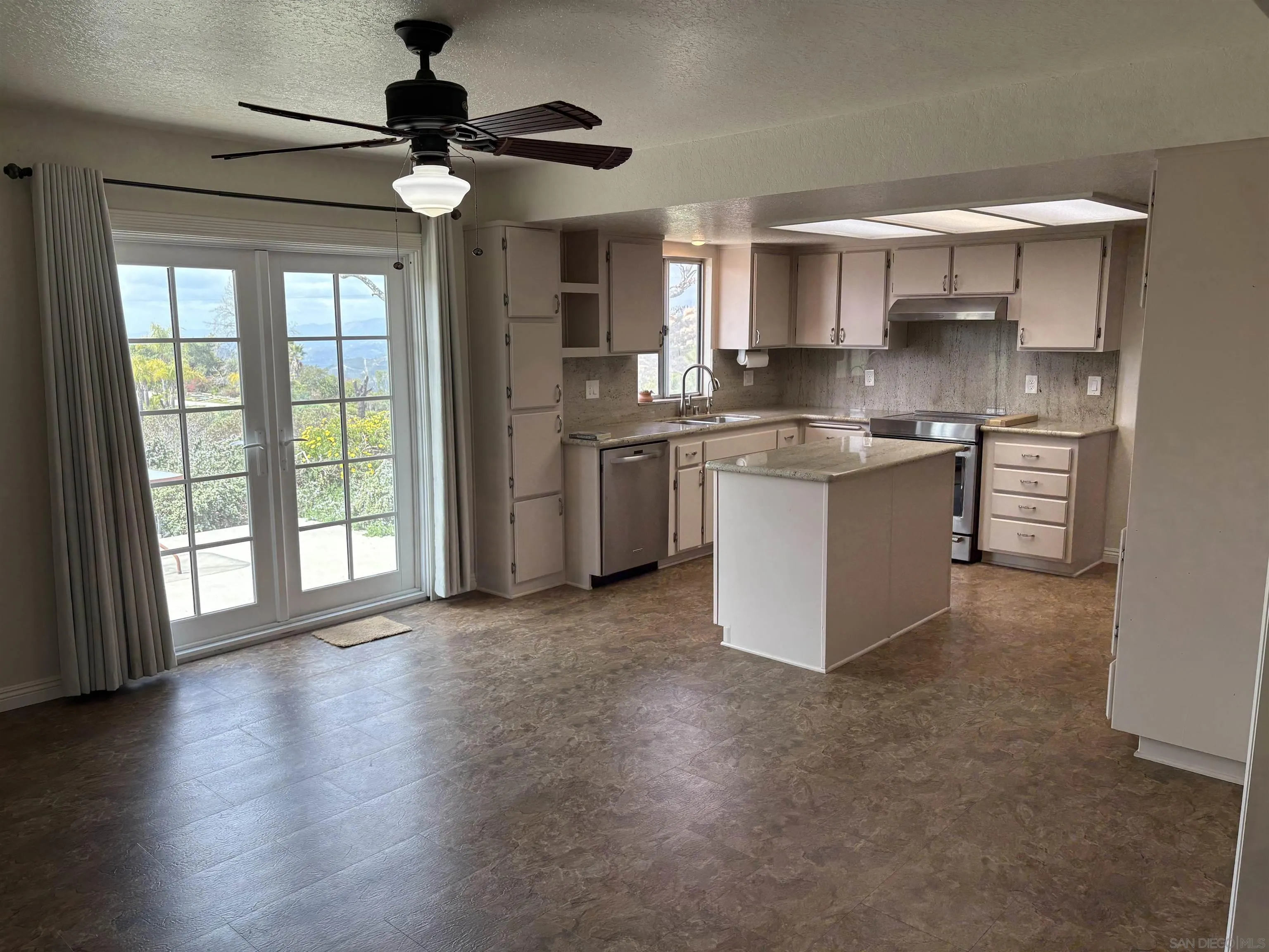 6702 Rainbow Heights Road Rainbow, CA 92028 - Photo 13 of 37 a kitchen with stainless steel appliances granite countertop a stove top oven a sink a counter space and cabinets
