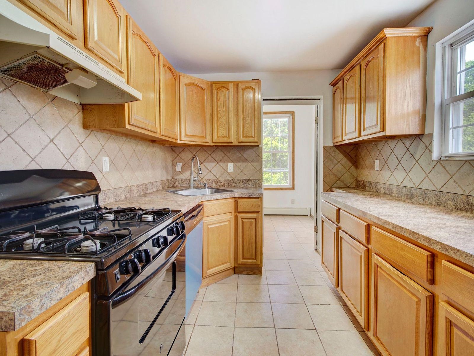 921 Paterson Plank Road, Unit 2 North Bergen, NJ 07047 - Photo 13 of 15 a kitchen with stainless steel appliances granite countertop a stove a sink and a microwave