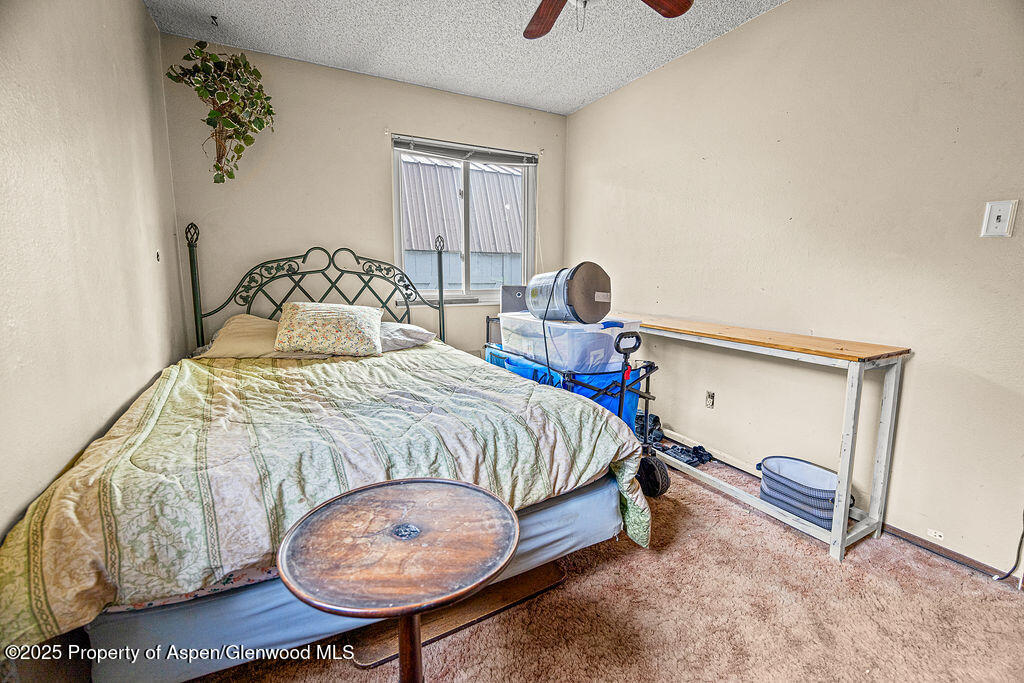 834 Ashley Road Craig, CO 81625 - Photo 19 of 38 a bedroom with a bed and a lamp on the dresser